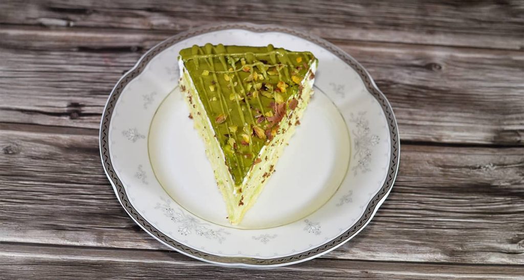 Porción de tarta rellena y cubierta de Crema de Pistachos